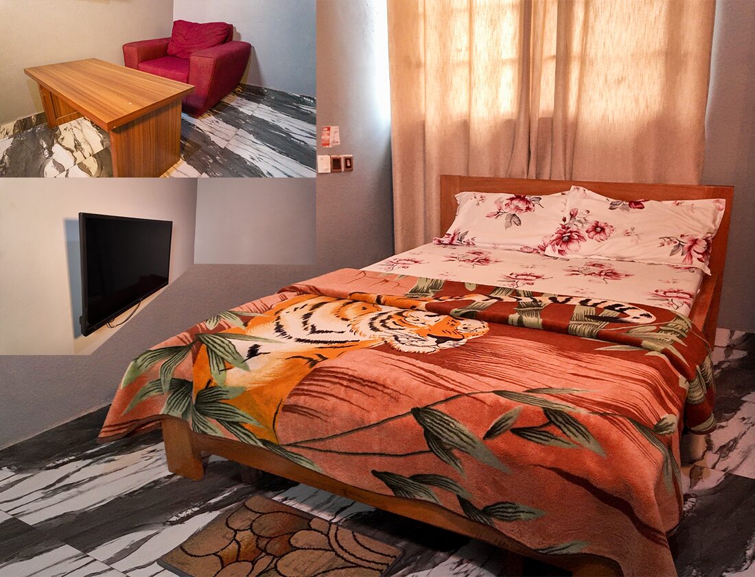 GHS150 room with a double bed, wall TV, desk and armchair
