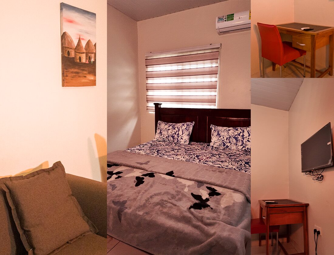 GHS350 room with a king size bed, air conditioner, DSTV, desk and sofa