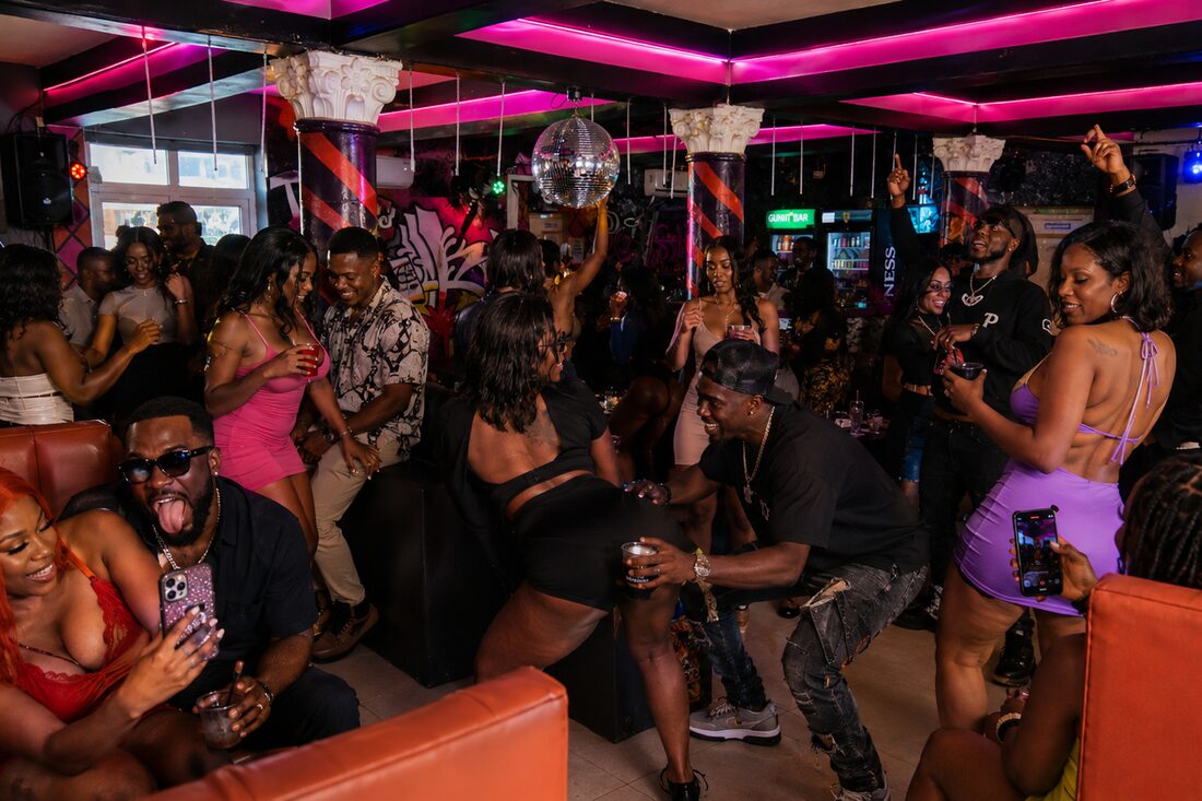 Guests dancing and socialising at the club with a disco ball and coloured lighting