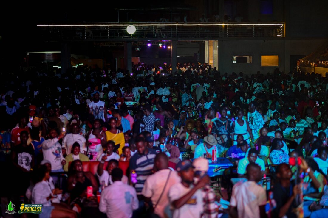 A large crowd seated at the event center during an evening programme with stage lighting